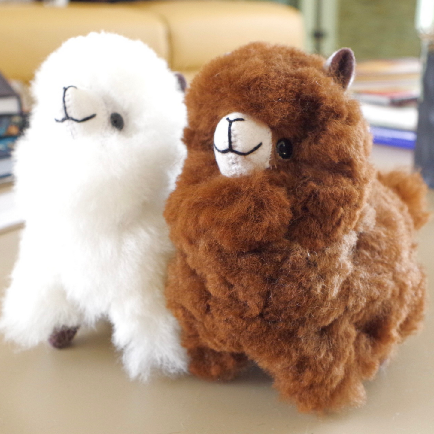 Home decor or gift soft llama plushies. 100% alpaca wool plushies. Made by Bolivian and Peruvian artisans. Colors available: Pink, Beige, White, Gray. Sizes: 8 x 8 in