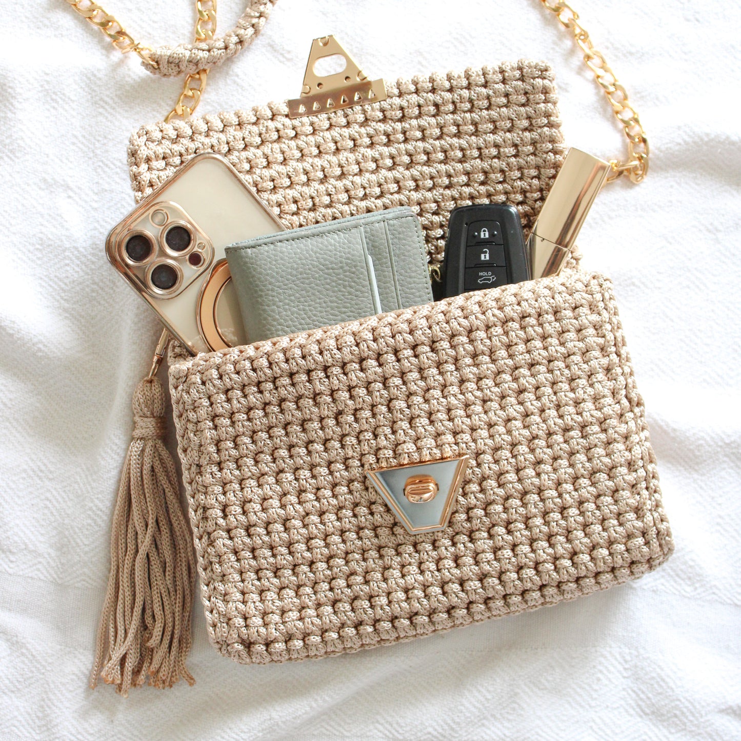 Handmade beige bag made to fit all your essentials. Textured crochet bags with gold details. Gold chains for a crossbody or shoulder look.