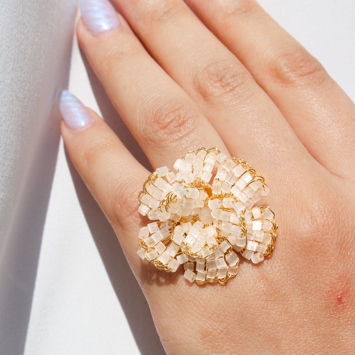 Handmade gold wire crochet flower ring with crystal beads, adjustable statement ring for women, artisan made beaded jewelry for weddings and gifts.