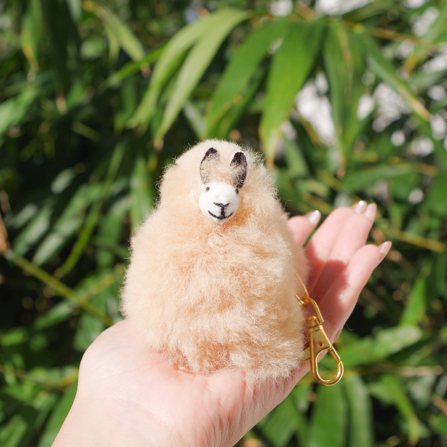 Beige Llama plushie pom pom keychain. Pom Pom size 3” in approx. Made with 100% alpaca wool. Made by Bolivian and Peruvian artisans. Colors Available: pink, white, beige, purple. Adult or children gift