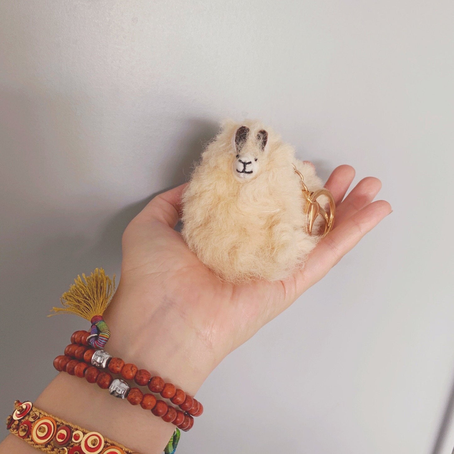 Beige Llama plushie pom pom keychain. Pom Pom size 3” in approx. Made with 100% alpaca wool. Made by Bolivian and Peruvian artisans. Colors Available: pink, white, beige, purple. Adult or children gift