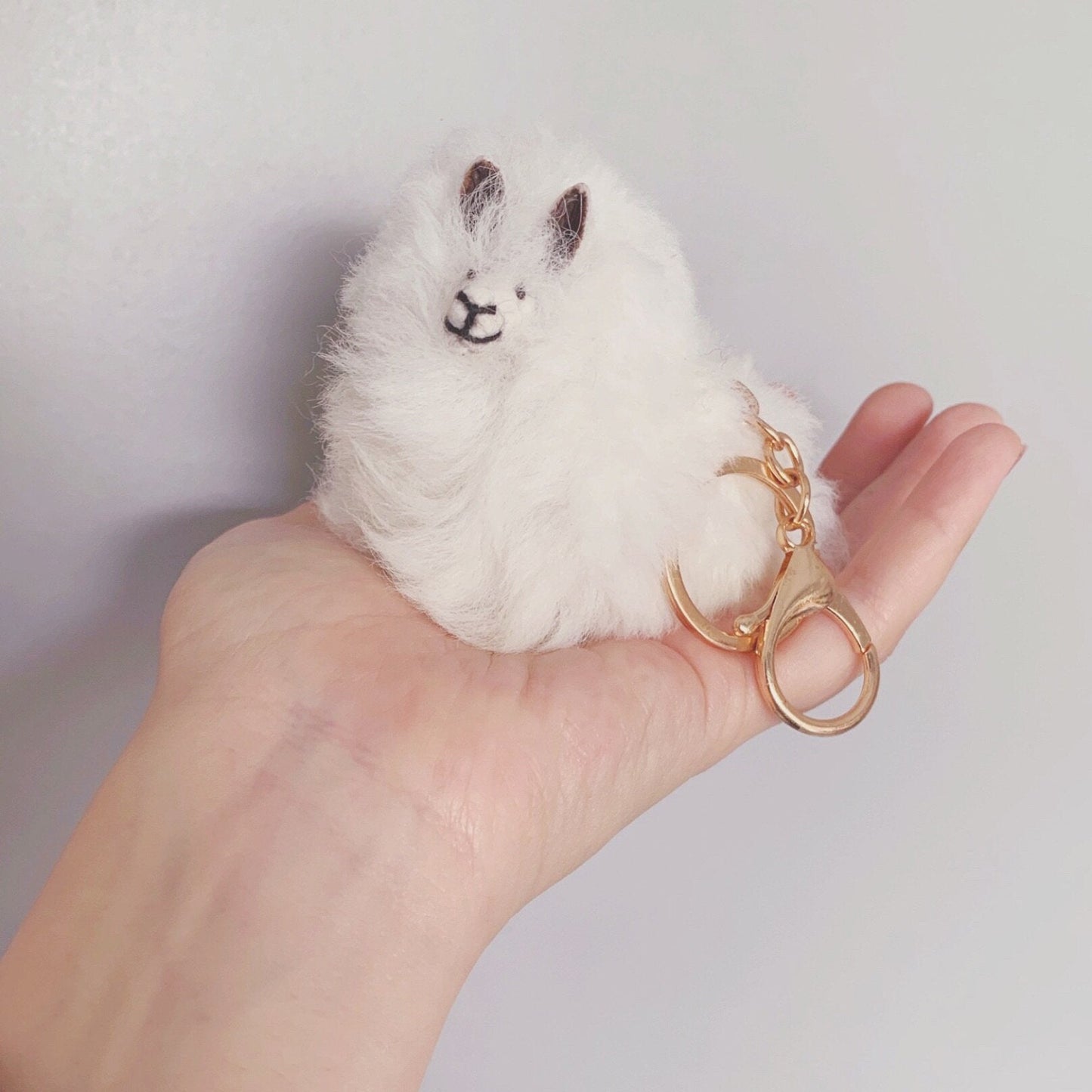 White Llama plushie pom pom keychain. Pom Pom size 3” in approx. Made with 100% alpaca wool. Made by Bolivian and Peruvian artisans. Colors Available: pink, white, beige, purple. Adult or children gift