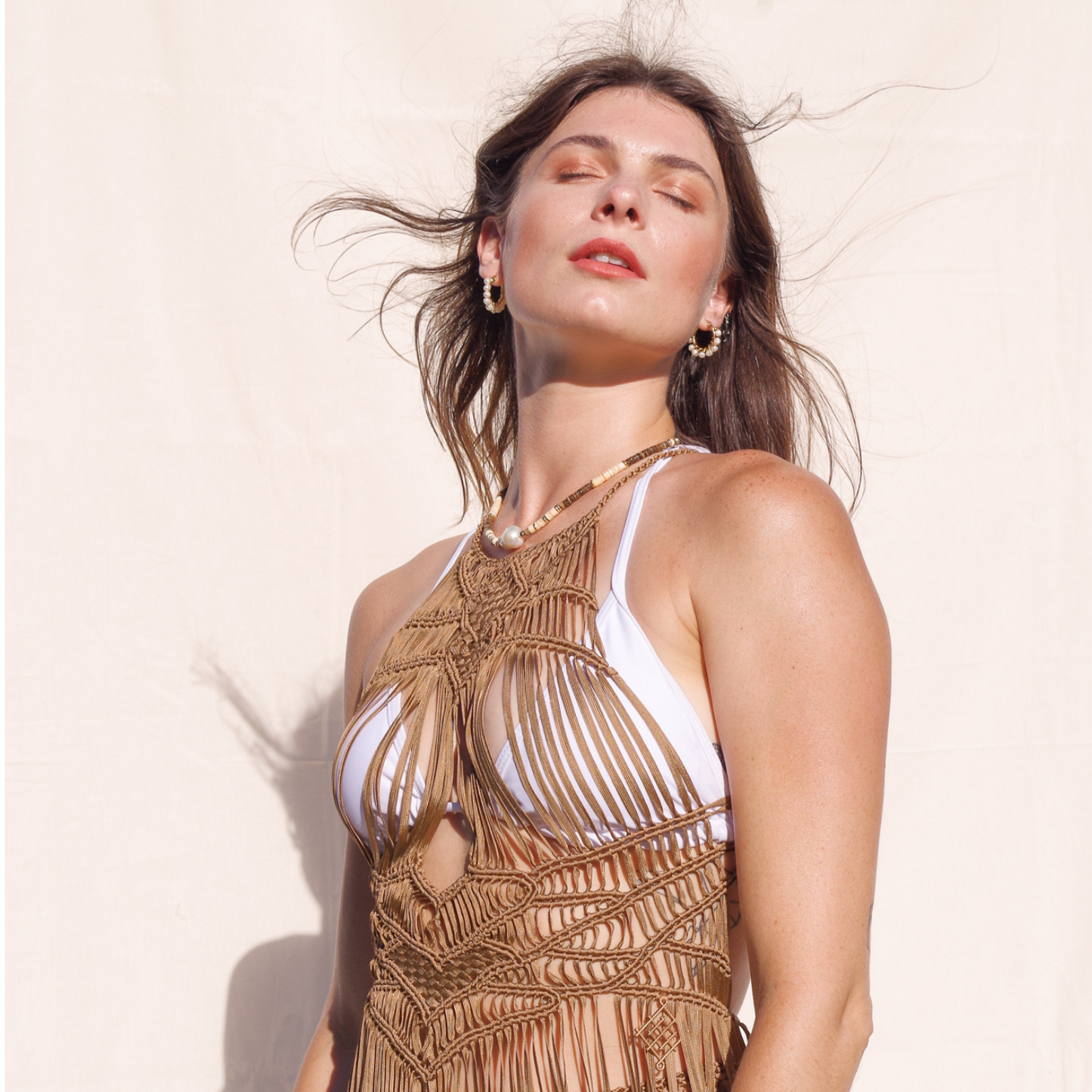 Luna Macrame Dress (one size fits S - XL) Macrame beach cover up or fashion accessory. Halter Top and Wrap Dress closure. Colors available: Beige, Gold, Caramel, Brown. Care instructions: Steam to straighten any wrinkles. Dry clean or gentle hand wash. 100% rayon. Ethically made by Bolivian artisans.