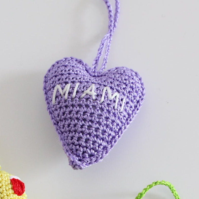 Crochet handmade miami heart charm bag. Make your bag look stylish and cute. Lilac handmade charm for bags. Bright and cheerful accessory for bags or backpacks.  Crocheted by hand with soft, durable yarn and finished with embroidery. Perfect travel souvenir MIAMI Handmade amigurumi crochet heart.