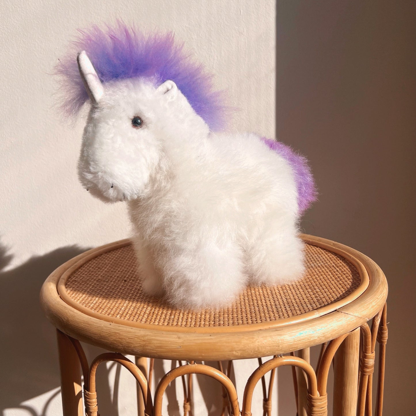 Alpaca wool unicorn plushie gift or home decoration. 100% baby  
alpaca wool. Handmade by Bolivian and Peruvian artisans. White % purple stuffed unicorn