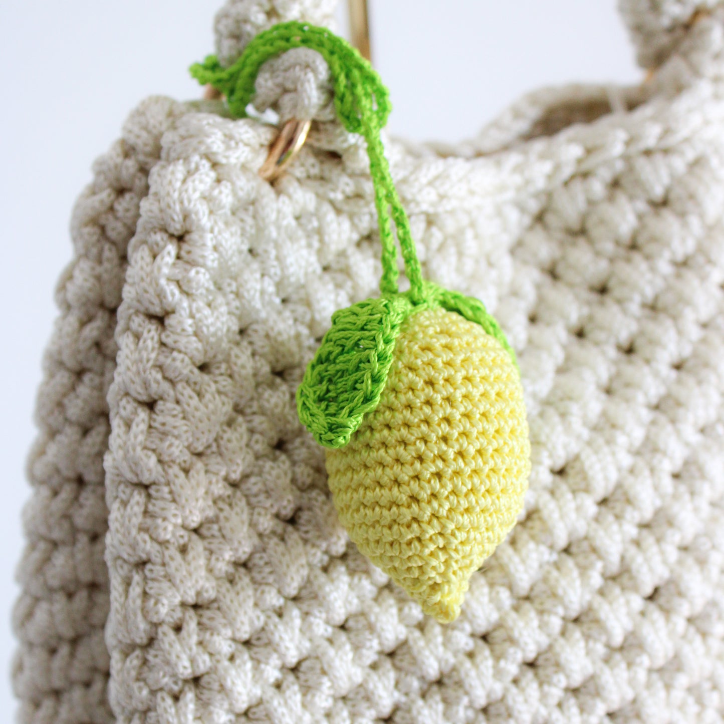 Bright and cheerful lemon accessory for bags or backpacks.  Crocheted by hand with soft, durable yarn and finished with a green crochet leaf detail. Handmade amigurumi crochet fruits.
