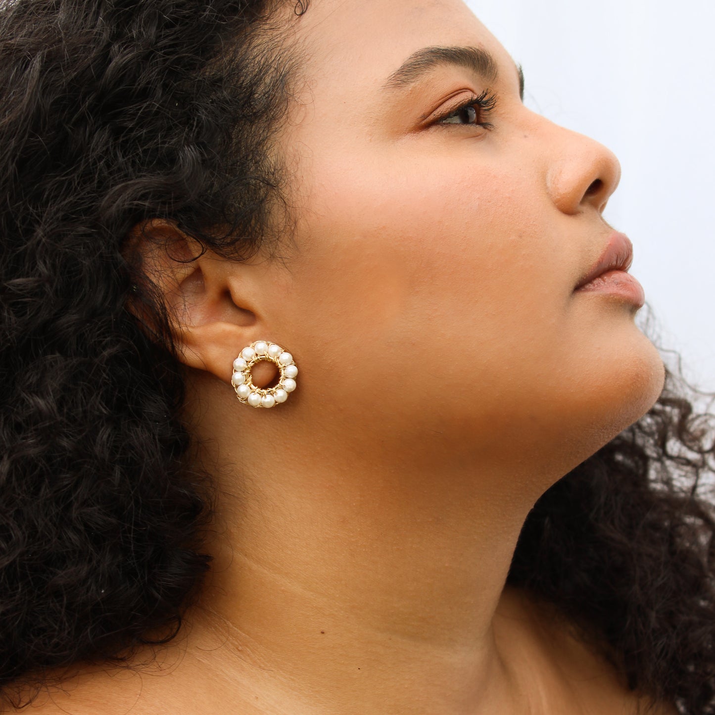 Double-ring earring design, handcrafted with pearls woven onto a gold-plated frame. A delicate chain connects the two cuffs on one side.  Lightweight geometric earrings