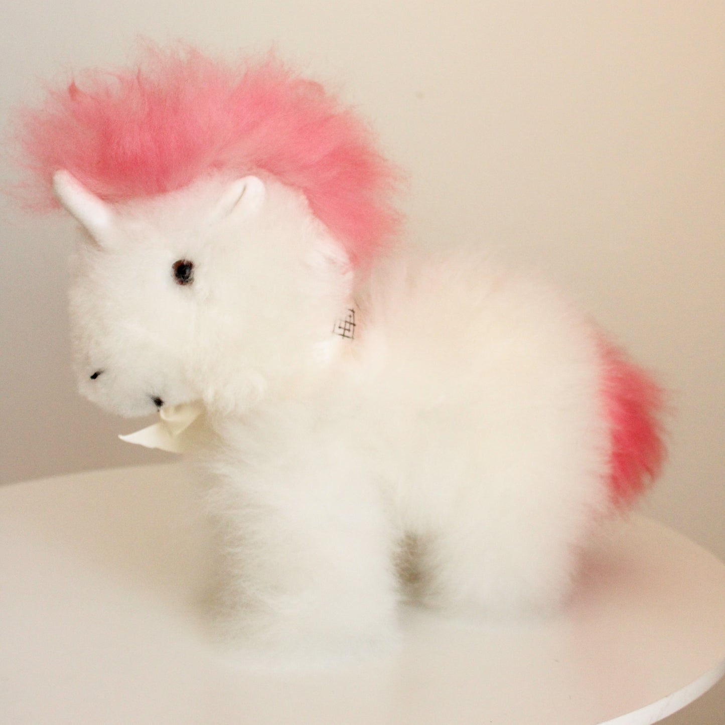 Alpaca wool unicorn plushie gift or home decoration. 100% baby  
alpaca wool. Handmade by Bolivian and Peruvian artisans. Pink stuffed unicorn