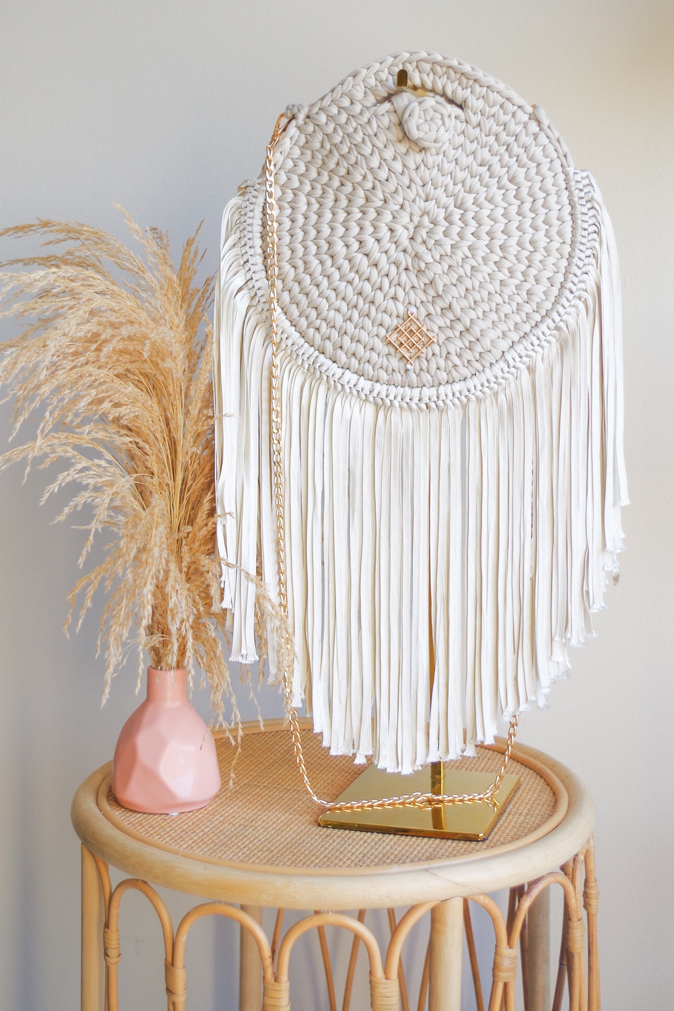 Rounded crossbody bag with fringes and chain strap. Made with crochet and macrame techniques. Boho Style. Color: Sand. Includes lining and zipper. Handmade in Bolivia. Hand Wash and professional cleaning only. 100% Rayon