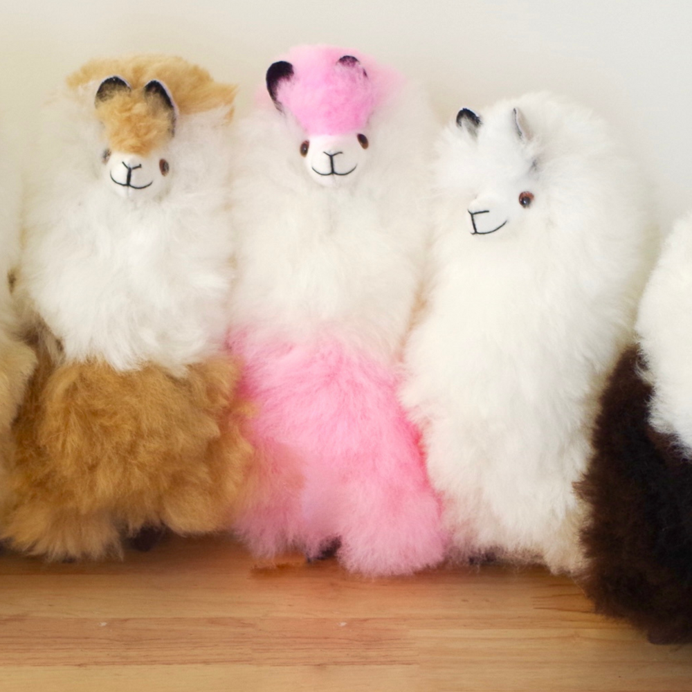 
            
                Load image into Gallery viewer, Llama plushie for home decor or gift. Medium size 12&amp;quot; in. Made with 100% alpaca wool. Made by Bolivian and Peruvian artisans. Colors Available: pink, white, beige, purple. Adult or children gift
            
        