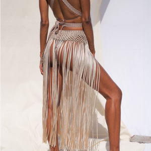 Anya Macrame Skirt or Beach Cover Up with tassels. One size fits all. Weaving width: 3" in Fringe length: 26" in approx. Tie Closure. Colors: Beige, Caramel, Black, Gold, Dusty Pink or Sage Green. Ethically made in Bolivia