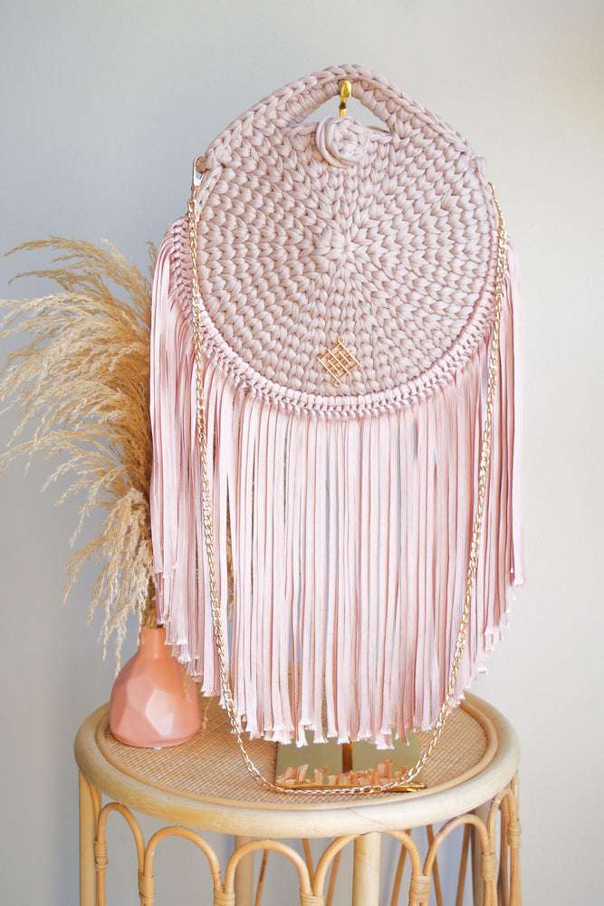 Blush Rounded crossbody bag with fringes and chain strap. Made with crochet and macrame techniques. Boho Style. Color: Blush. Includes lining and zipper. Handmade in Bolivia. Hand Wash and professional cleaning only. 100% Rayon