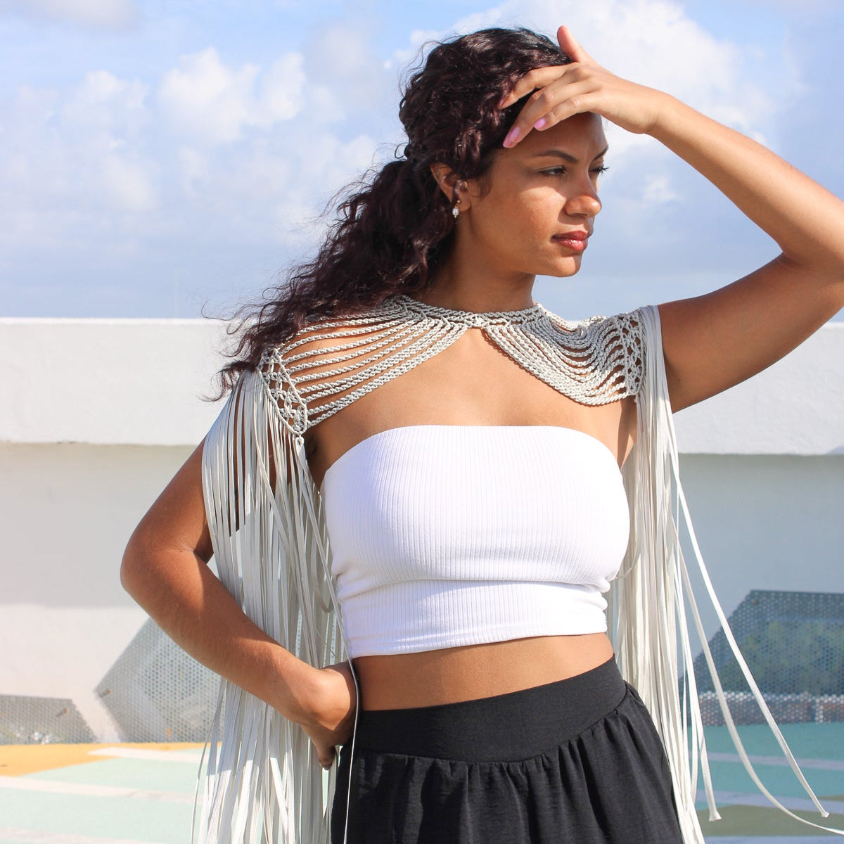 Silver color macrame cape with intricate woven detail and flowy fringe