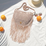 Beige Macrame crossbody bag with fringes. Includes lining and zipper. Handmade in Bolivia. Hand Wash and professional cleaning only. 100% Rayon