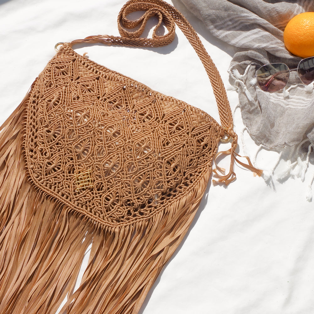 Light Brown Macrame crossbody bag with fringes. Includes lining and zipper. Handmade in Bolivia. Hand Wash and professional cleaning only. 100% Rayon