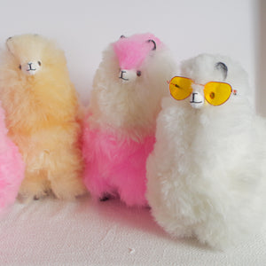 Llama plushie for home decor or gift. Medium size 12" in. Made with 100% alpaca wool. Made by Bolivian and Peruvian artisans. Colors Available: pink, white, beige, purple. Adult or children gift