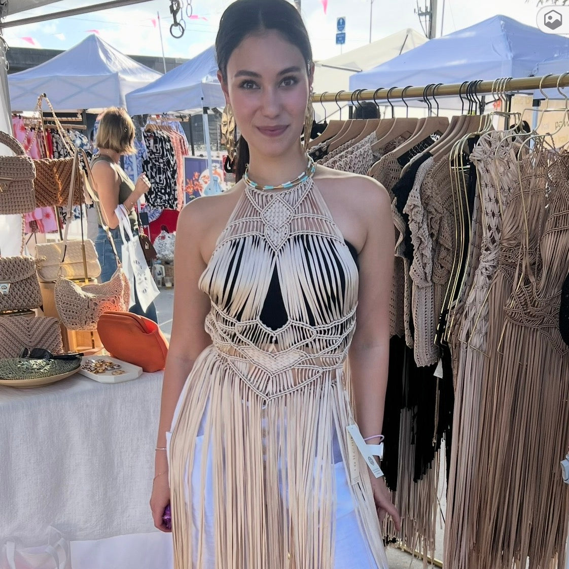 Woman wearing a Luna fringe Dress beige at an outdoor market.