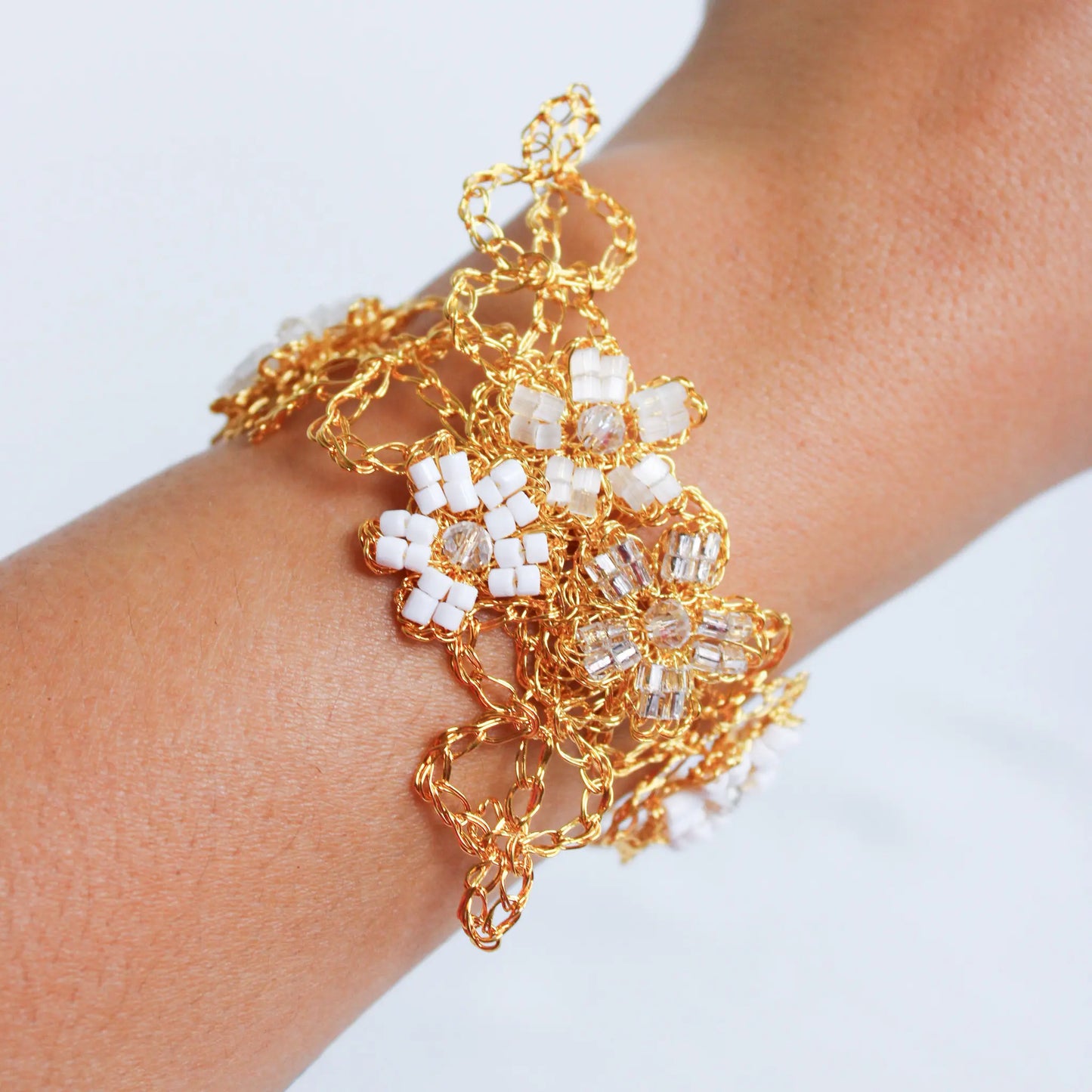 Delicate and intricate crochet bracelet with white and clear flower patterns. Stylish crochet handmade breaded bracelet.