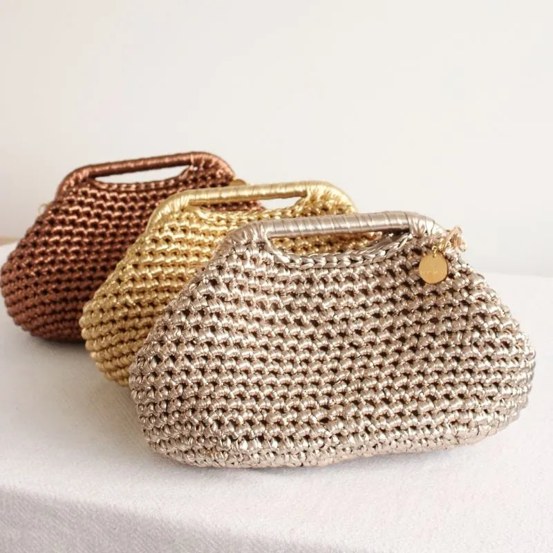 Three hand made crochet bags, one gold and one bronze and the beige on a white clean surface
