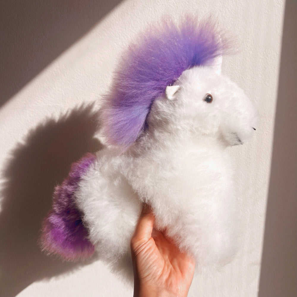 
                      
                        Alpaca wool unicorn plushie gift or home decoration. 100% baby  
alpaca wool. Handmade by Bolivian and Peruvian artisans. Purple stuffed unicorn
                      
                    
