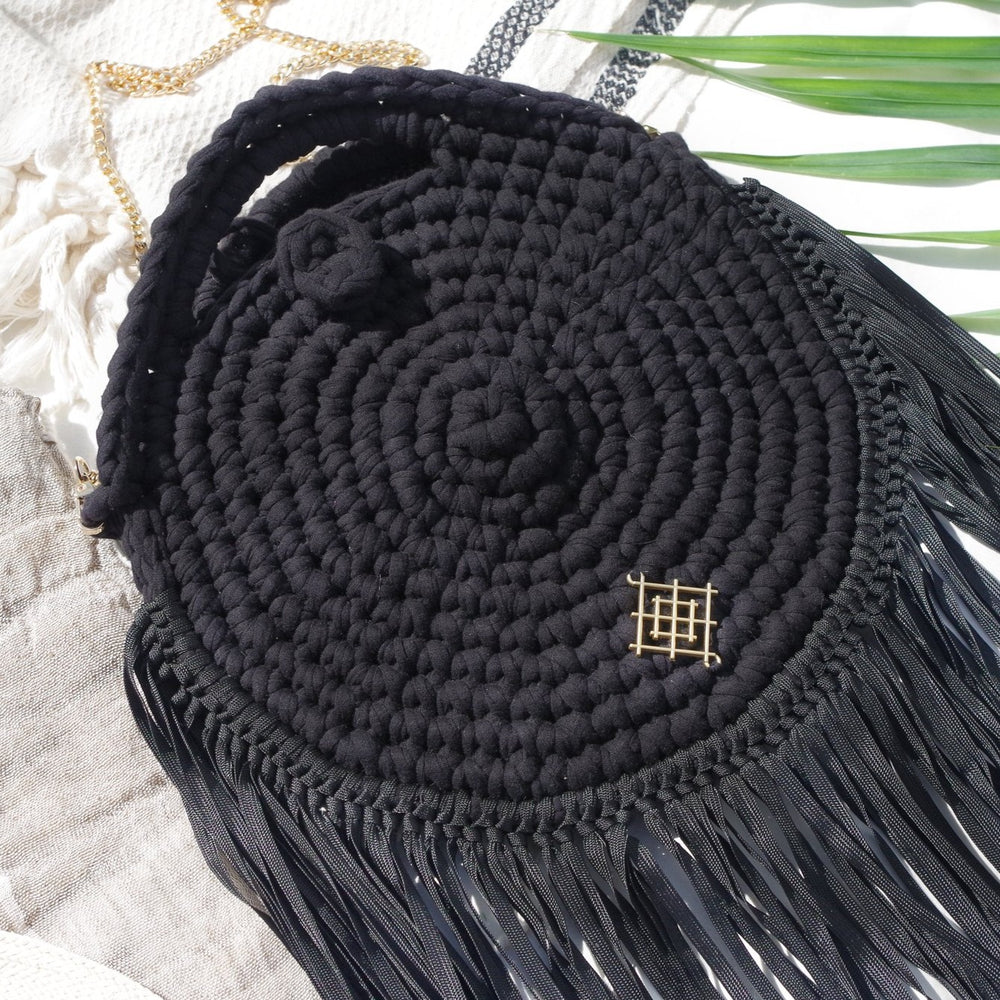 Rounded crossbody bag with fringes and chain strap. Made with crochet and macrame techniques. Boho Style. Color: Black. Includes lining and zipper. Handmade in Bolivia. Hand Wash and professional cleaning only. 100% Rayon